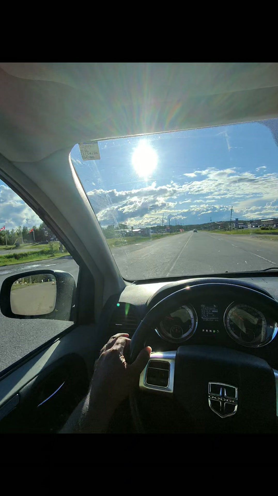 View from inside van on sunny highway with clear blue sky.