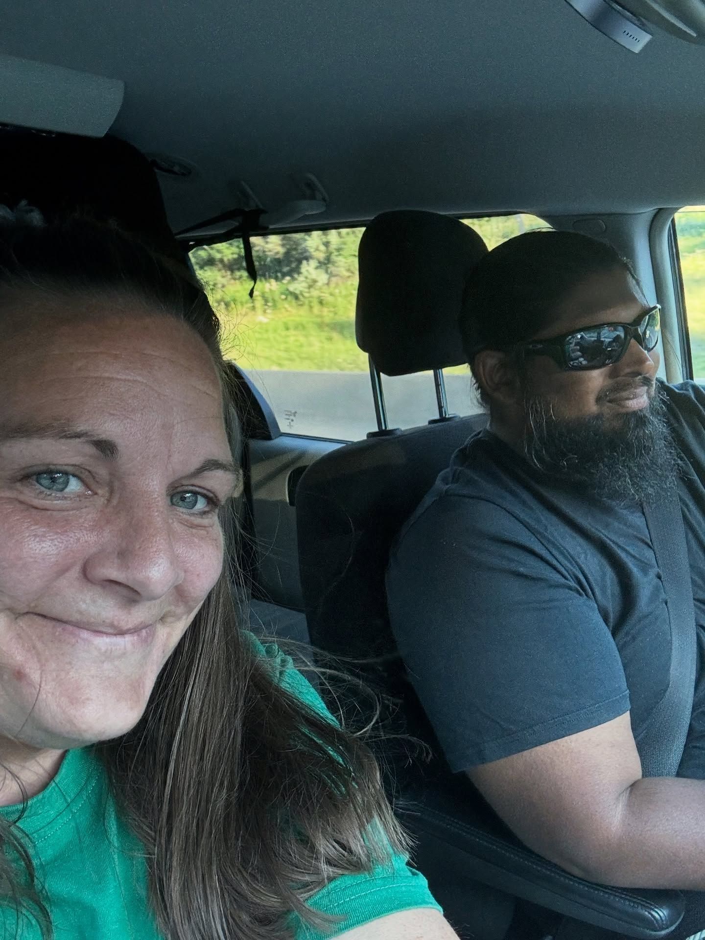 Chey and Mark smile inside the van during a drive.