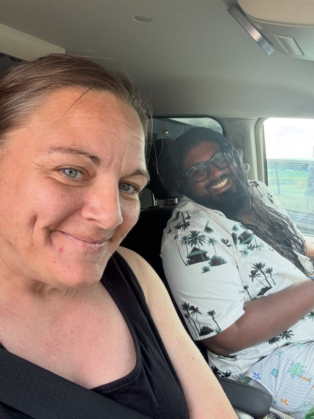Two people smile together in van looking at camera.