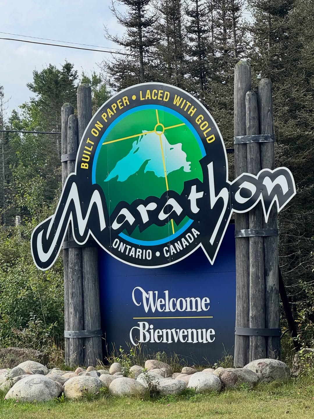 Marathon welcome sign featuring Indigenous art with nation emblem and compass rose.