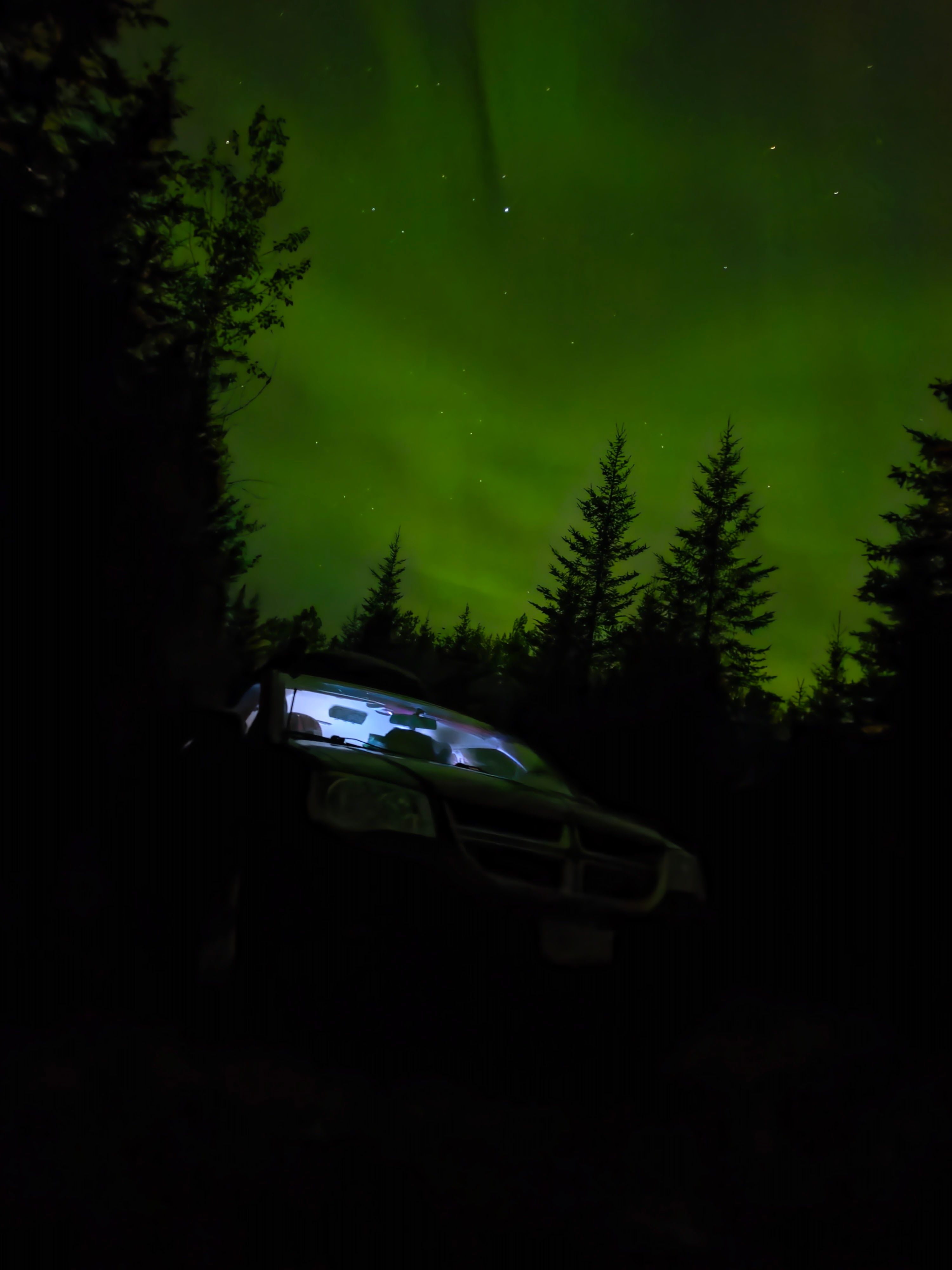 Green northern lights over the van at night